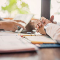 Business people negotiating a contract, they are pointing on a document and discussing together. Two businessmen are negotiating.